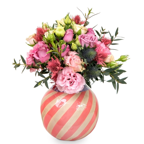 Bouquet in pink shades in a pink striped vase