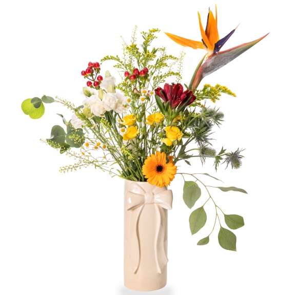 White vase with bow and light flower arrangement with strelitzias