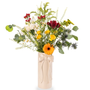 White vase with bow and light flower arrangement in yellow and red